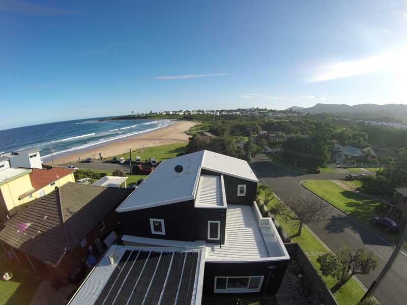 ariel view of a brown house with a white roof