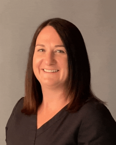 A woman in a black shirt is smiling for the camera.