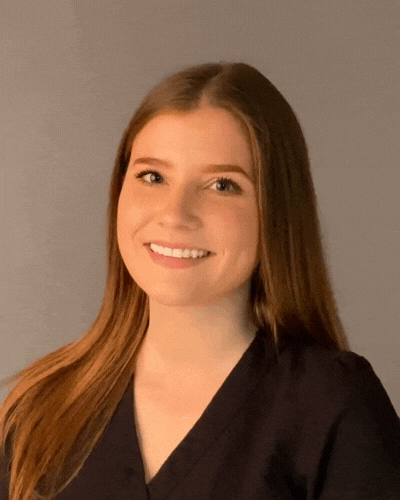 A woman in a black shirt is smiling for the camera.
