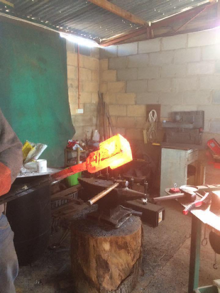 Red hot metal being taken out from the furnace for shaping