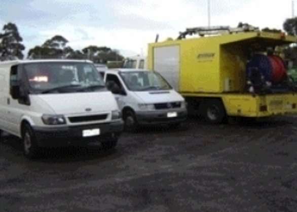 yellow truck and white vans