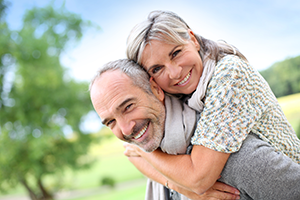 A happy senior couple sitting on the deck of a sail boat on a calm blue sea