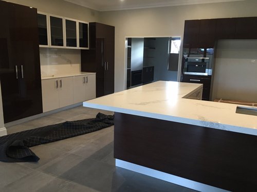 black corner kitchen island with white overflow counter tops