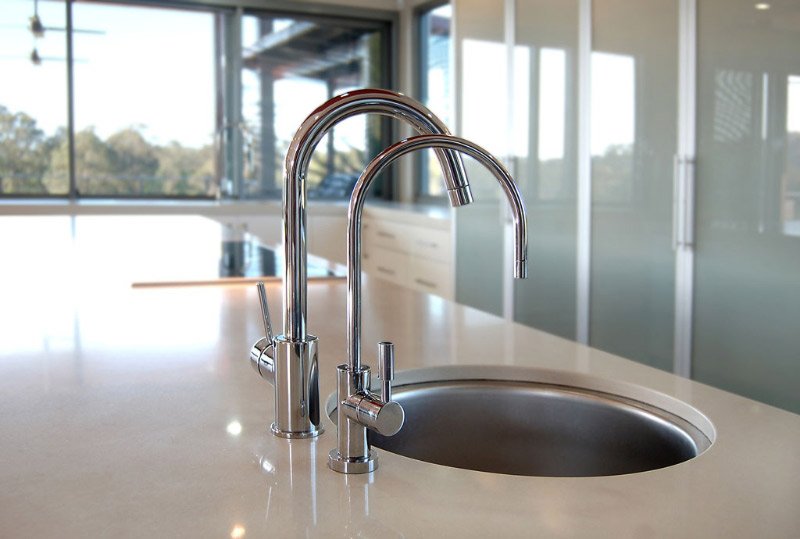 kitchen sink surrounded by white counter tops