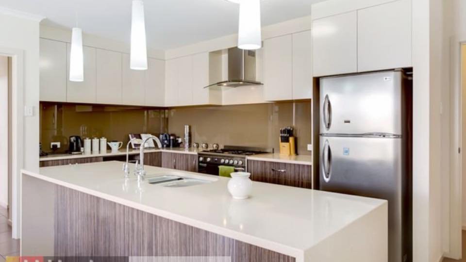 brown kitchen island with white waterfall counter top