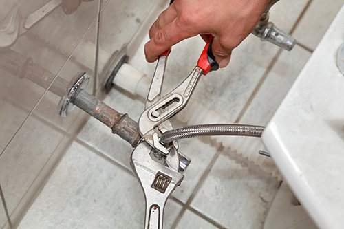A Man Works On Plumbing Repairs In Rochester Ny A Man Works On Plumbing Repairs In Rochester Ny