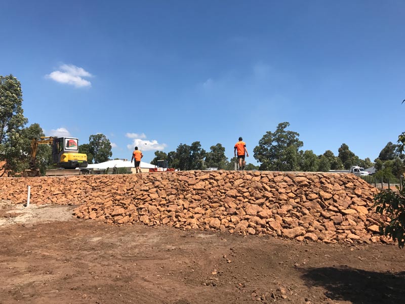 workers standing on a retaining wall