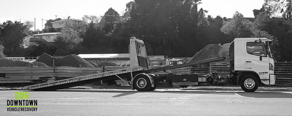 black and white picture of tow truck with long ramp