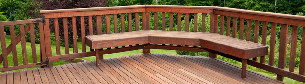 A fenced decking area with a corner seat