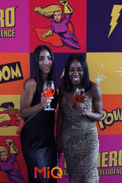 Two women standing in front of a wall that says power