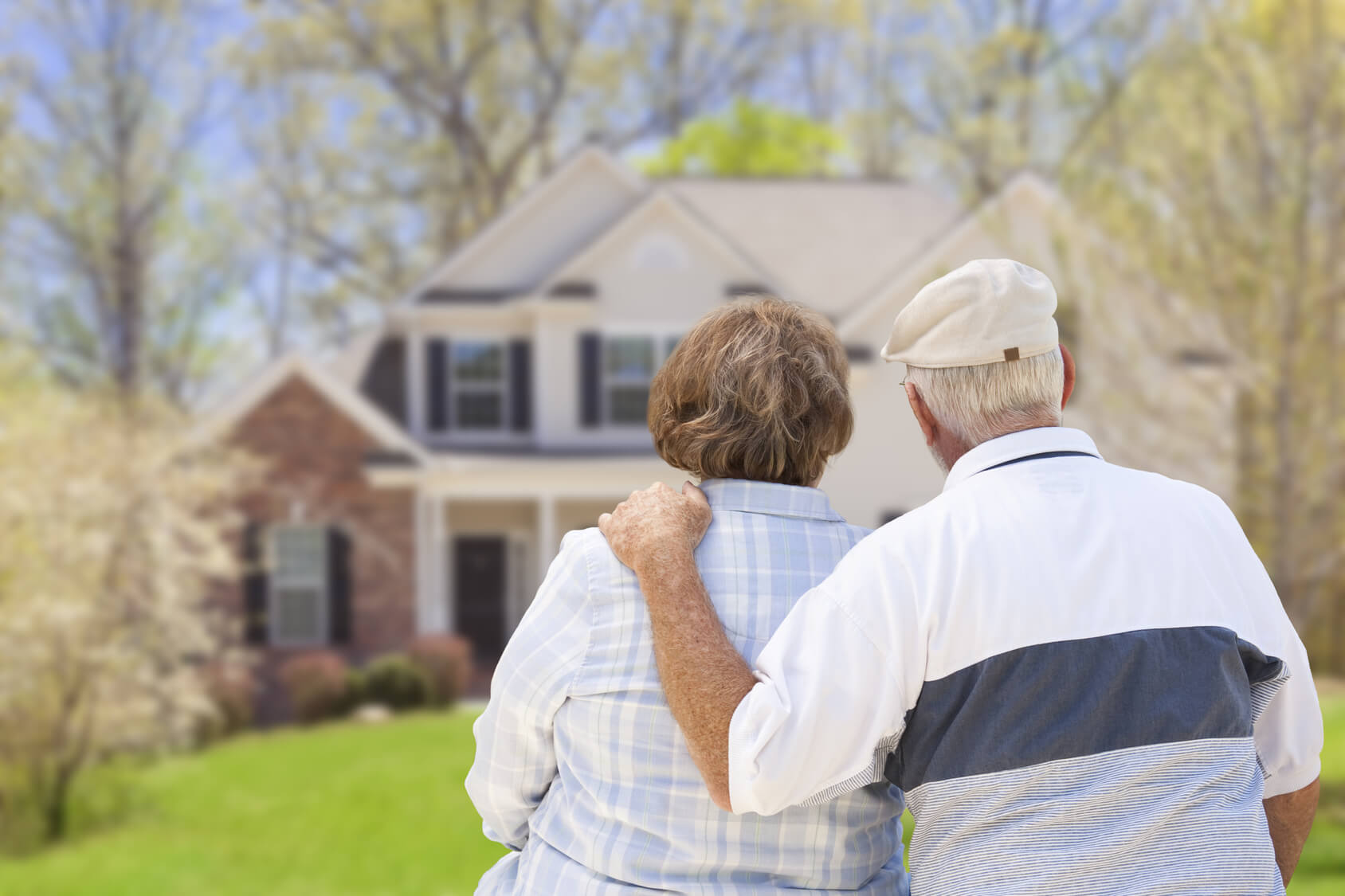 A man and a woman are standing in front of a house.