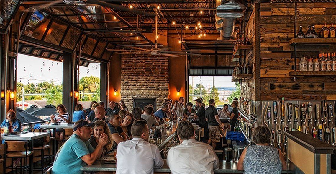 A group of people are sitting at tables in a restaurant.
