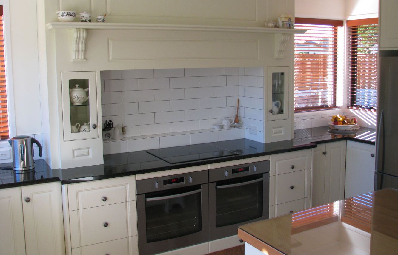 A white kitchen with two ovens