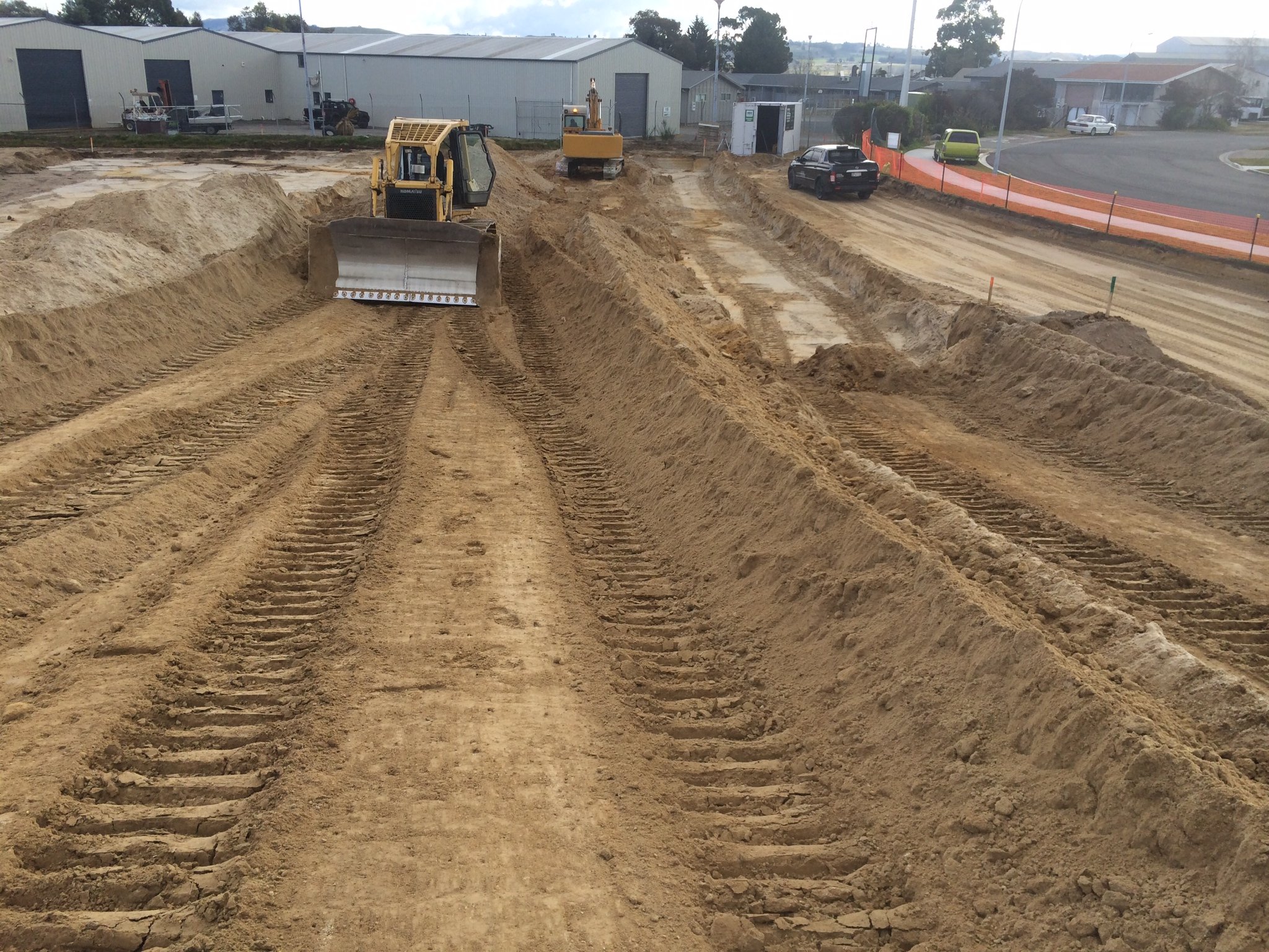 Sand and gravel being dumped by trucks on the construction site