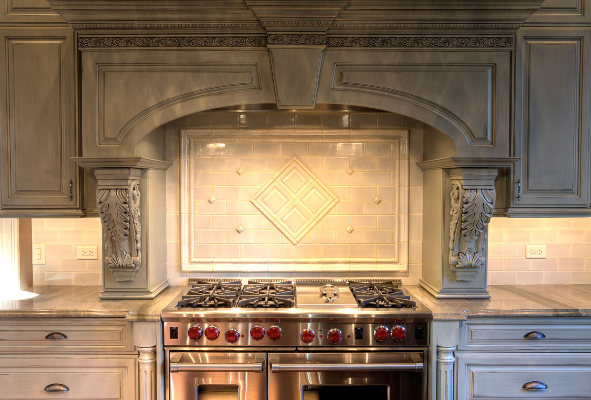 A kitchen with a stove top oven and a hood.
