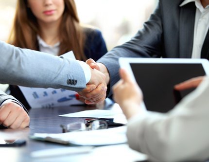 Professionals shaking hands after getting accounting assistance
