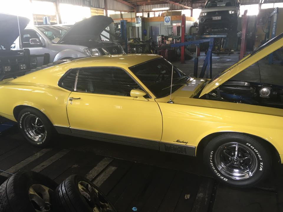 a yellow car with the hood open