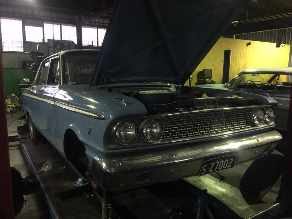 blue car with the hood open