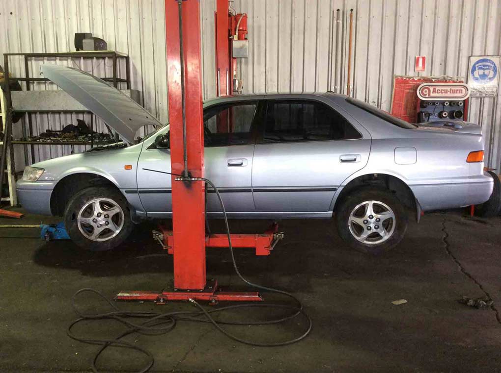 a silver car on a red lift