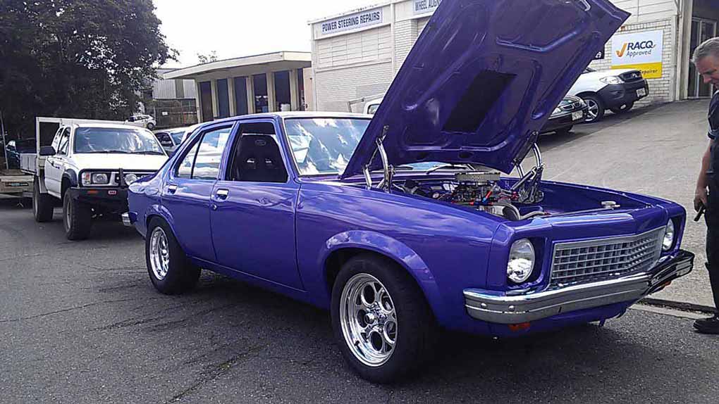 a blue or purple car with the hood open