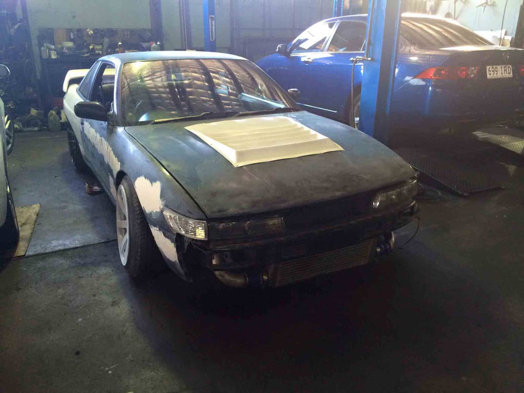 a green car with white on the hood