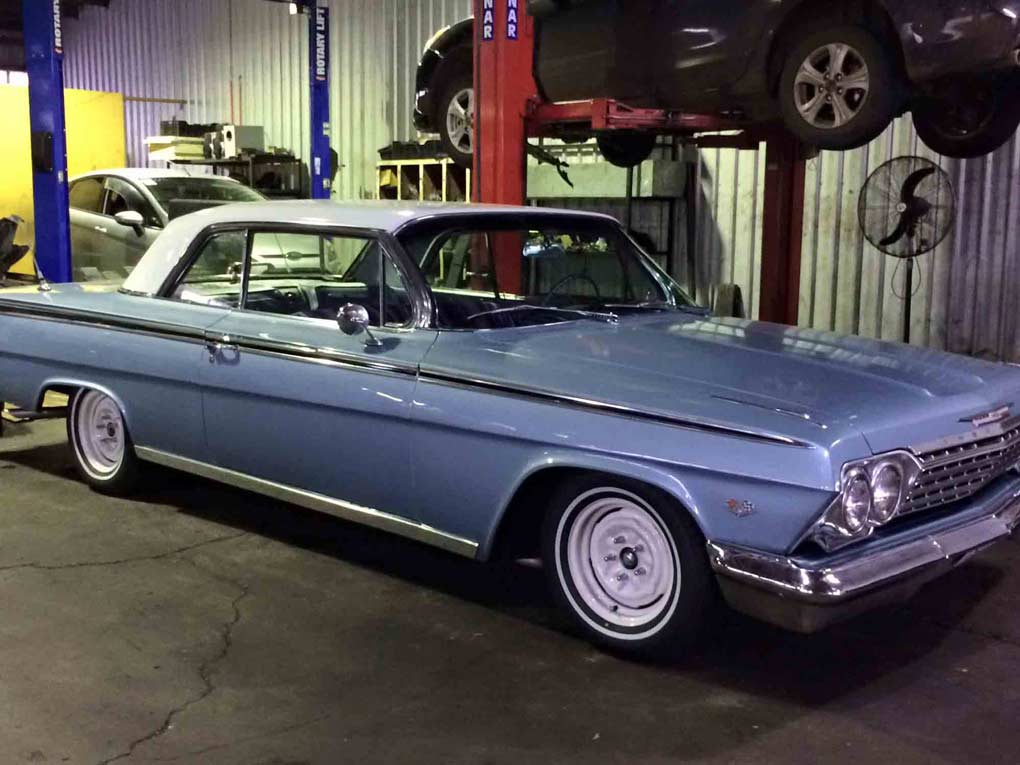 an old blue car with a white roof