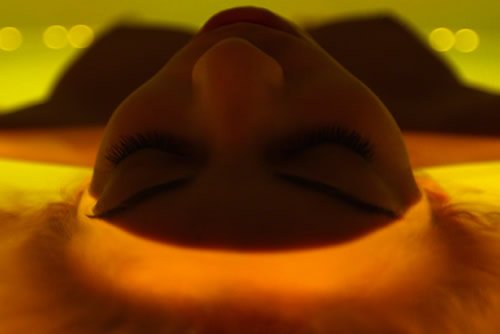 woman lying in water with flowers