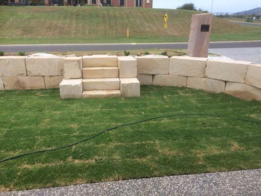 stone retaining wall with steps and grass