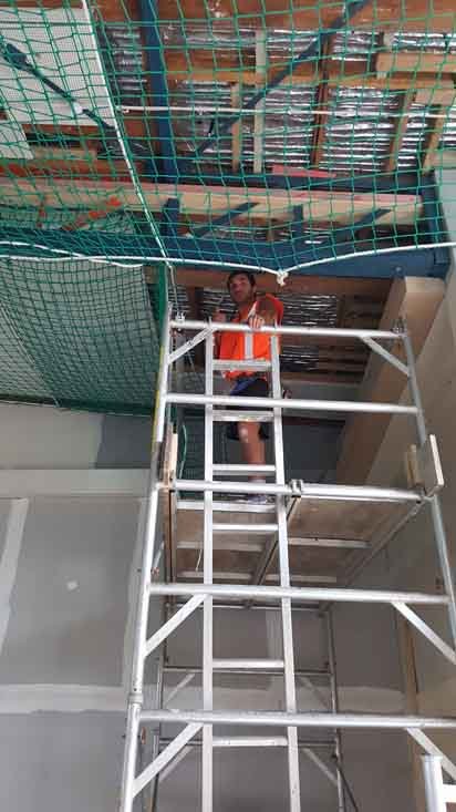 Professional installing the safety net at the construction site 