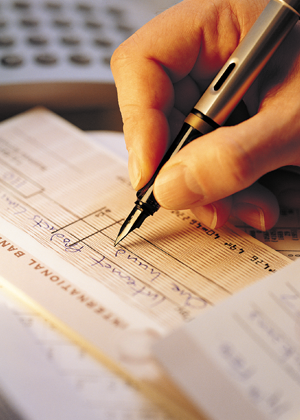 Person writing a cheque with a fountain pen