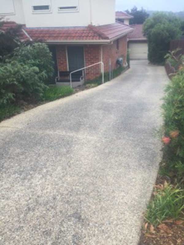 grey driveway next to a red building