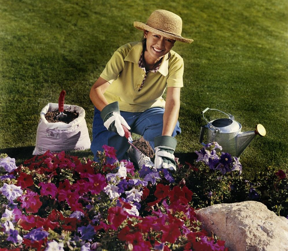 Woman planting some flowers with landscaping supplies from The Hunter Valley & Newcastle