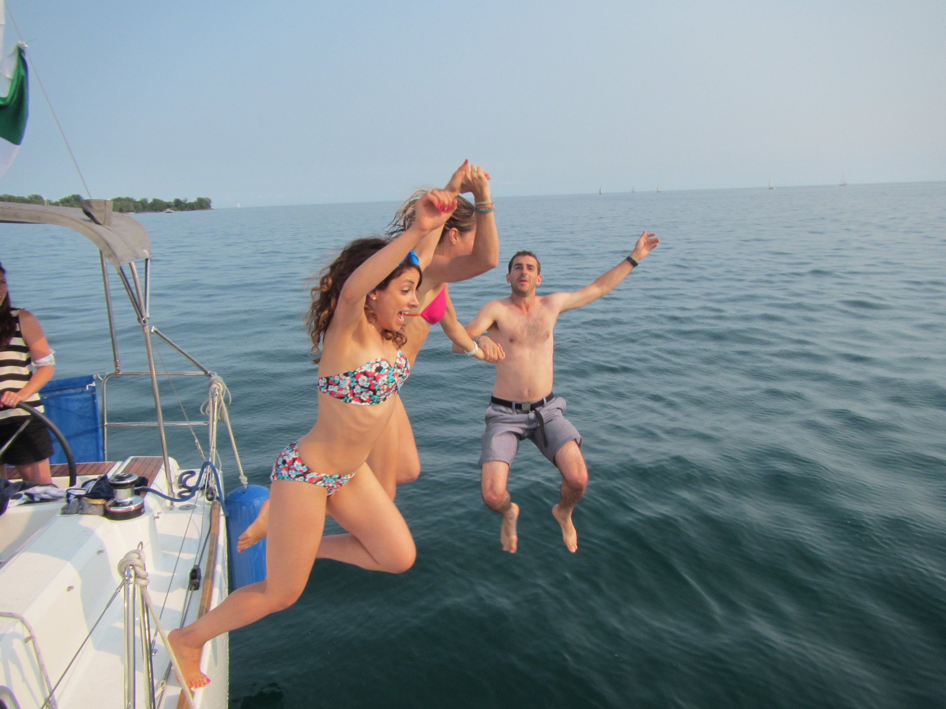Man and Woman jumping from a boat to the lake