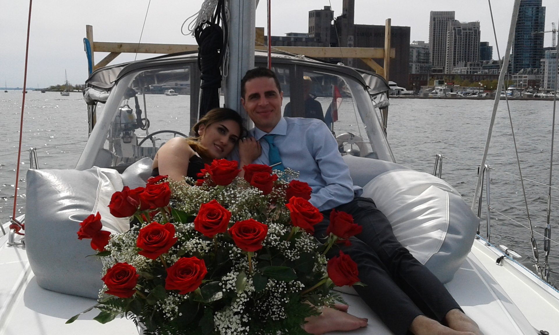Engaged couple on a yacht with red roses