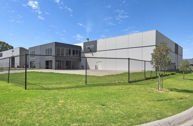 fenced in commercial building next to grass
