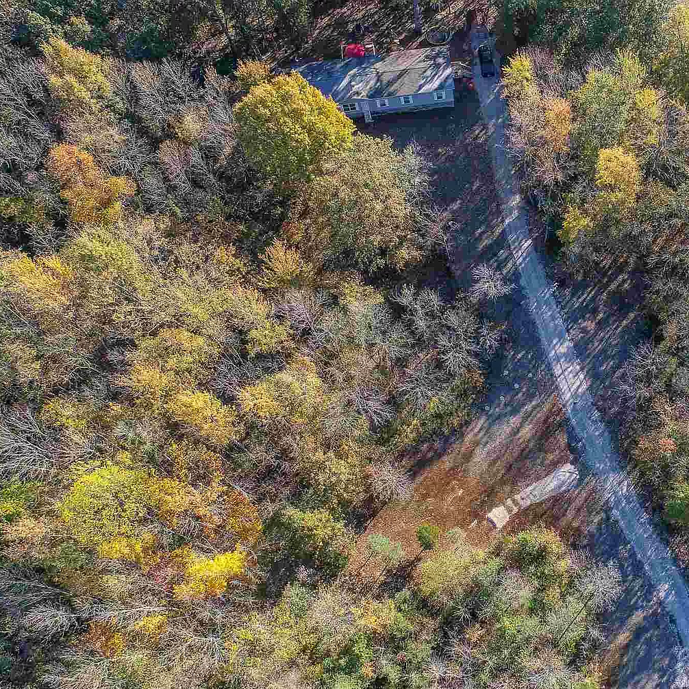 An aerial view of a road going through a forest.