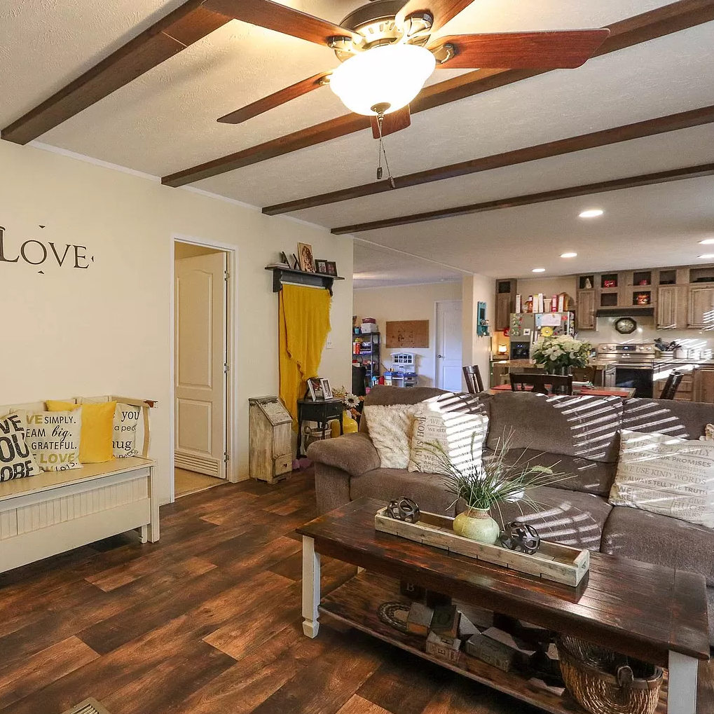 A living room with a ceiling fan and a sign that says love