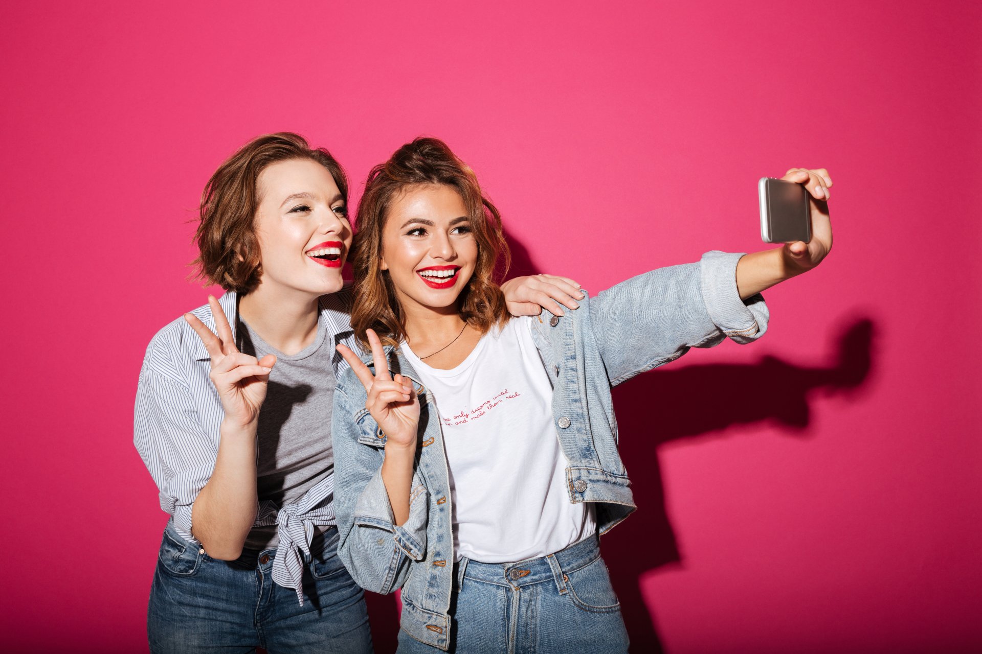 2 women taking a selfi with bright white smiles