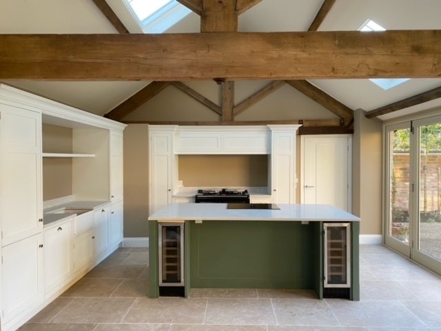 A new solid surface kitchen counter top corner with a wine cooler below and hardwood floor.
