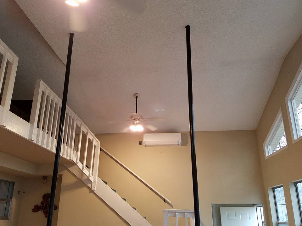 A living room with stairs and a ceiling fan