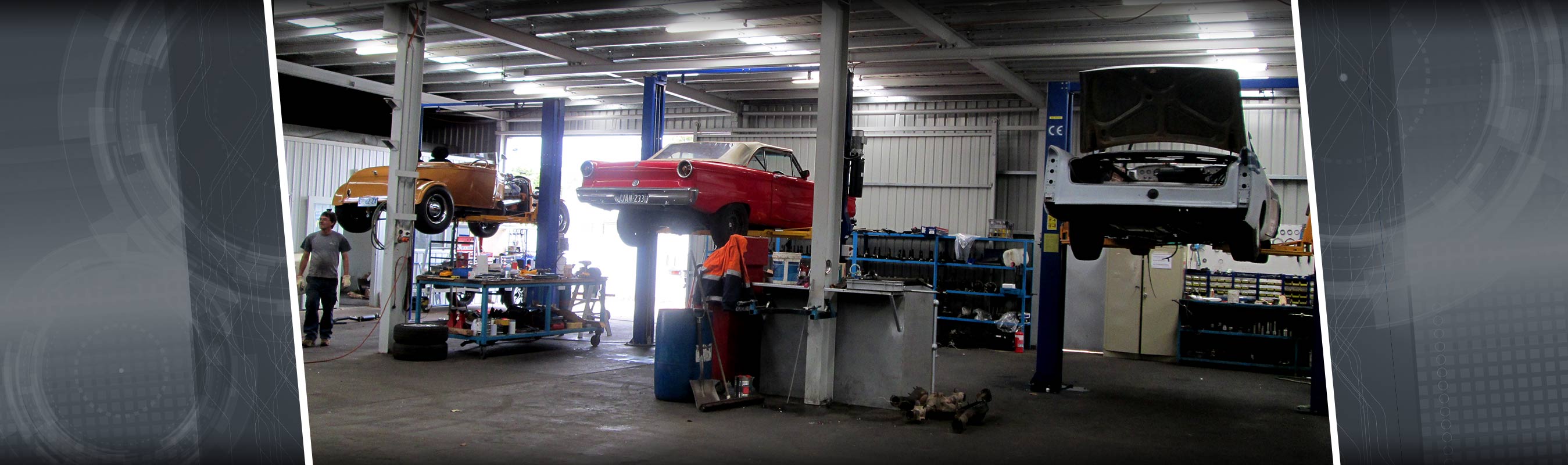  aikman engineering workshop with cars on hydraulic lift  
