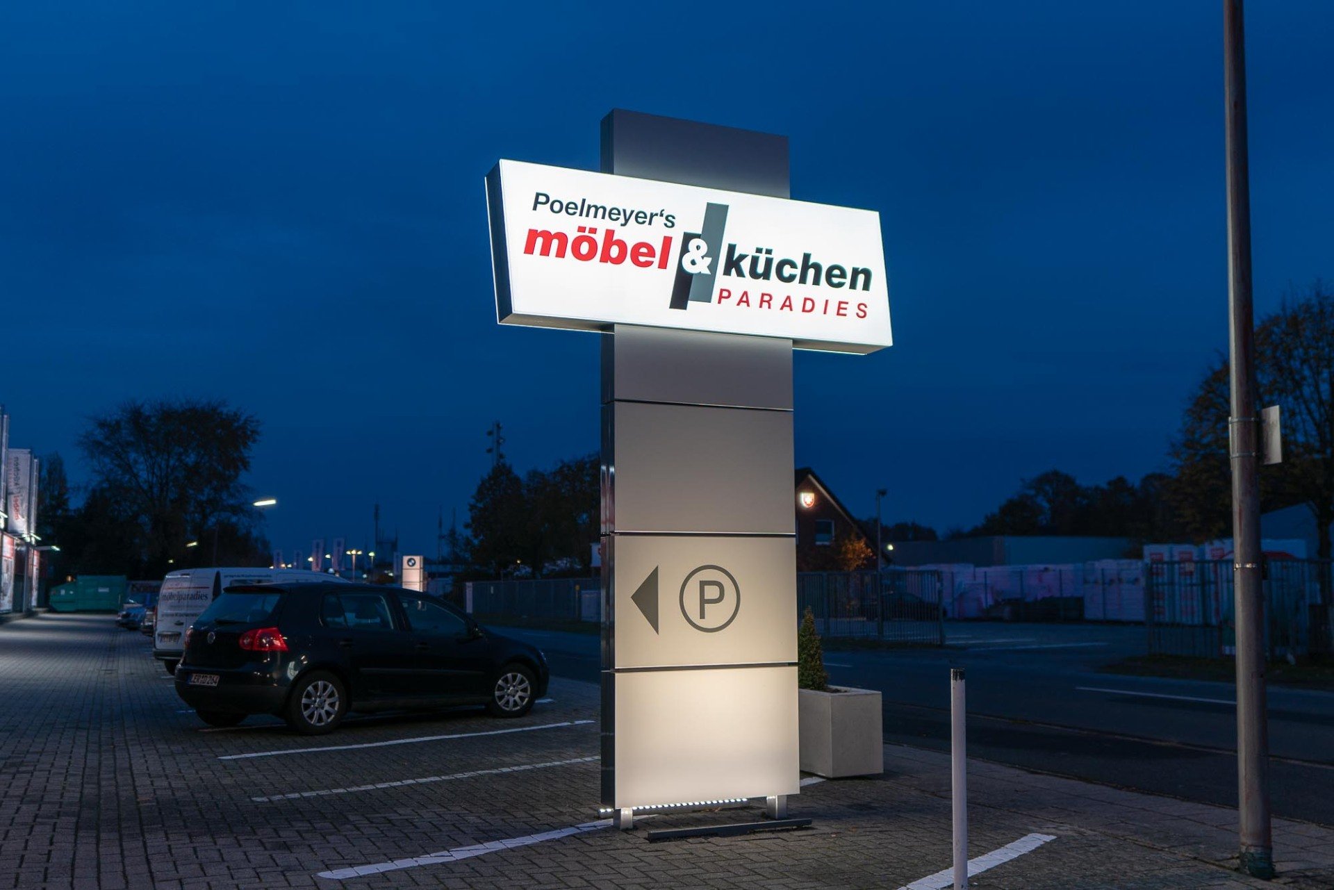 Freestanding illuminated cabinet pylon sign at a commercial property