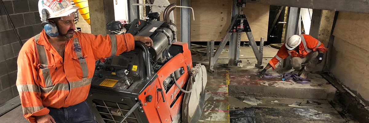 two workers using concrete cutting machinery