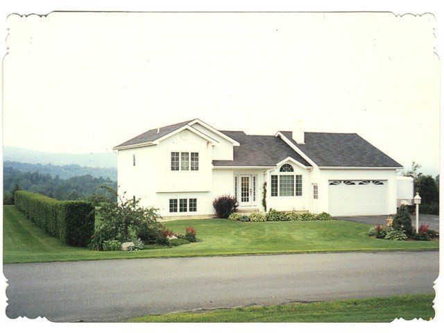 A picture of a white house with a black roof