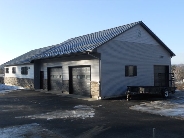 A garage with a trailer parked in front of it