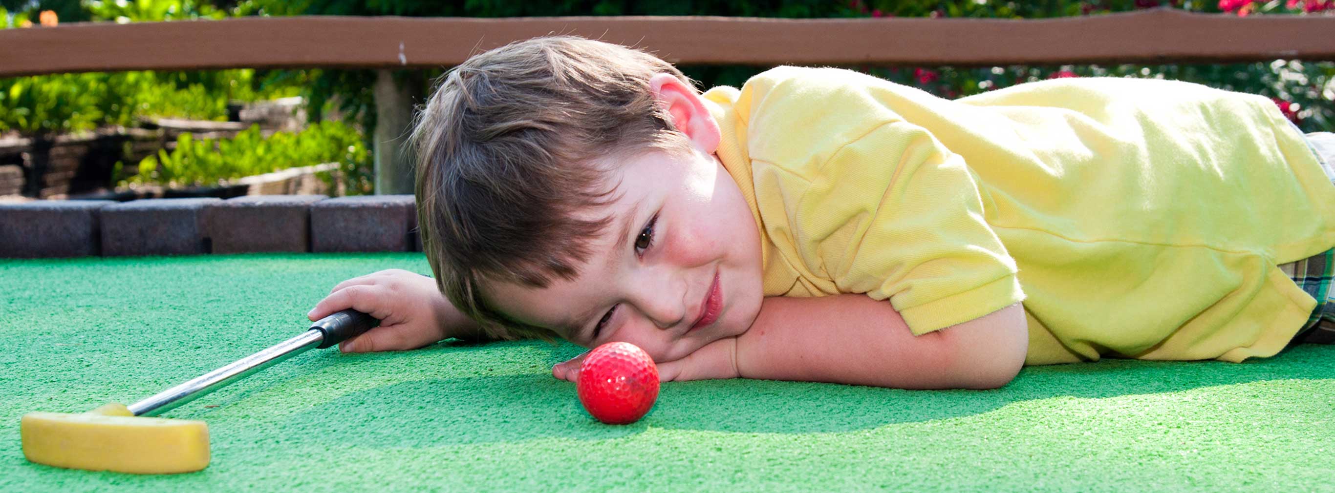 carnival amusements of s a child playing miniature golf