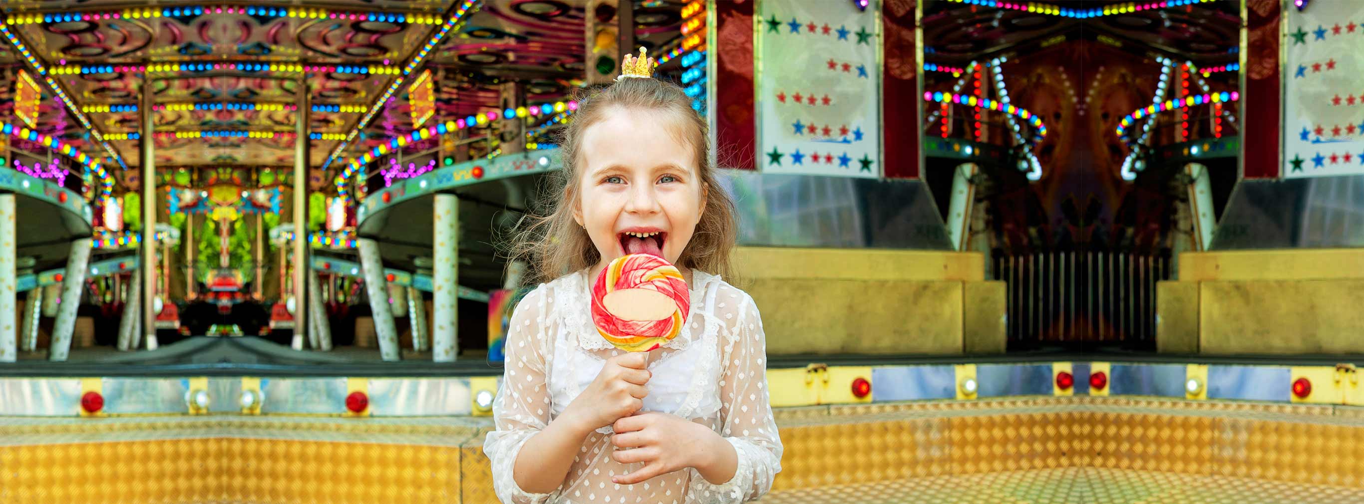 carnival amusements of s a cute little girl with lollipop at amusement park