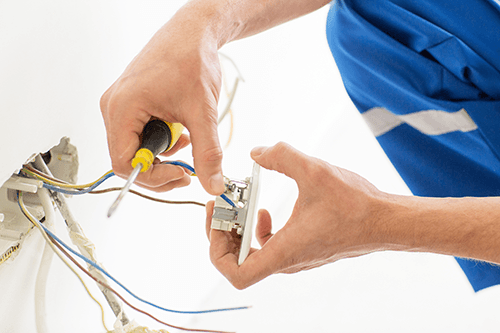 Experienced electrician fixing socket