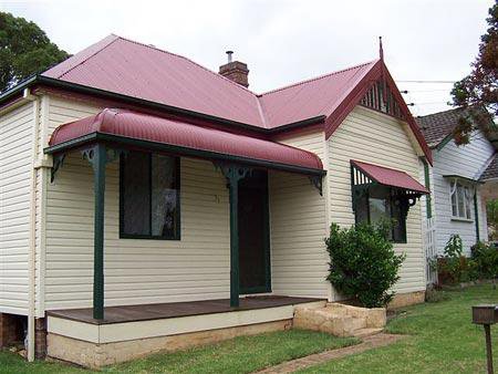a small home with a red roof and a patio