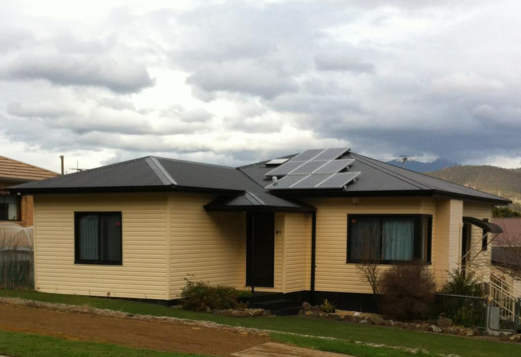 a yellow home with a black roof